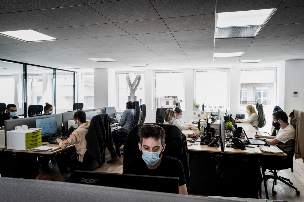 People wearing protective masks work in a small business on September 1, 2020 in Lyon, on the first day face masks become mandatory within SME amid the crisis linked with the Covid-19 pandemic caused by the novel coronavirus. (Photo by JEFF PACHOUD / AFP)