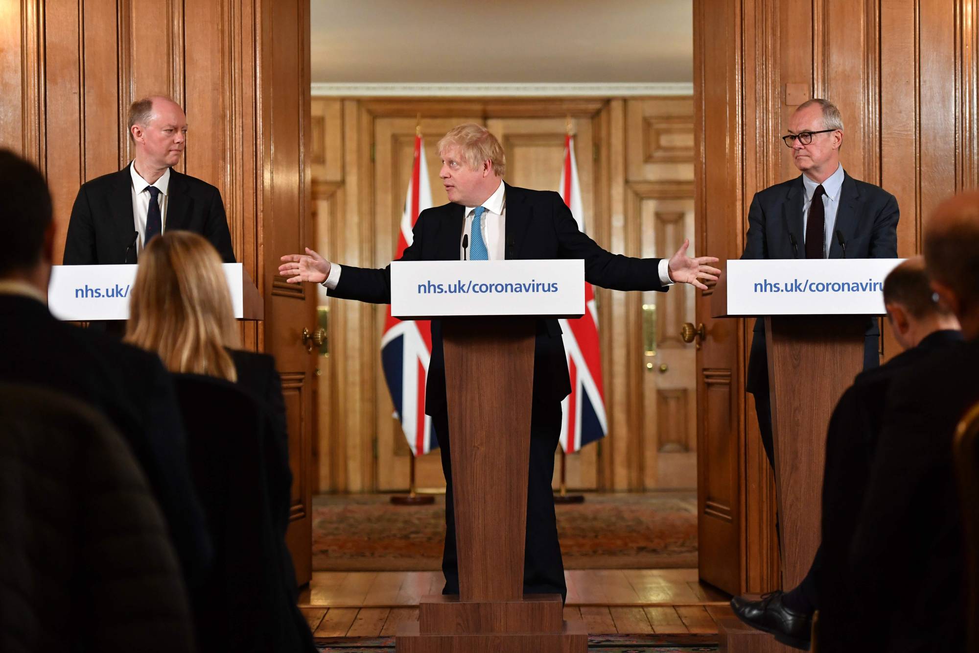 (FILES) In this file photo taken on March 19, 2020 Chief Medical Officer Chris Whitty (L) and Chief Scientific Adviser Patrick Vallance (R) look on as Britain's Prime Minister Boris Johnson addresses a news conference to give a daily update on the government's response to the novel coronavirus COVID-19 outbreak, inside 10 Downing Street in London on March 19, 2020. - British Prime Minister Boris Johnson spent the night in intensive care after being admitted with a deteriorating case of coronavirus, prompting serious concerns on April 7, 2020 about his health and the government's response to a still-escalating outbreak. (Photo by Leon Neal / POOL / AFP)