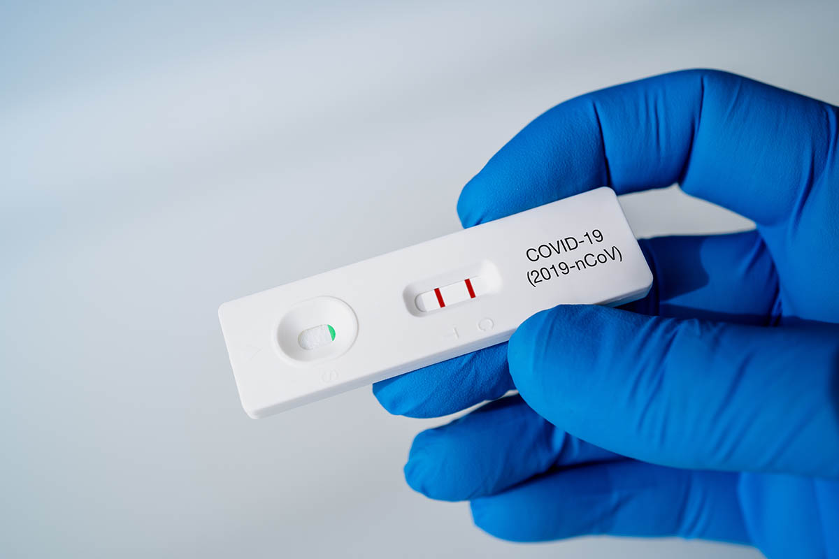Doctor holding a Positive Result for COVID-19 with test kit for viral disease COVID-19 2019-nCoV. Lab card kit test for coronavirus SARS-CoV-2 virus. Fast test COVID-19.