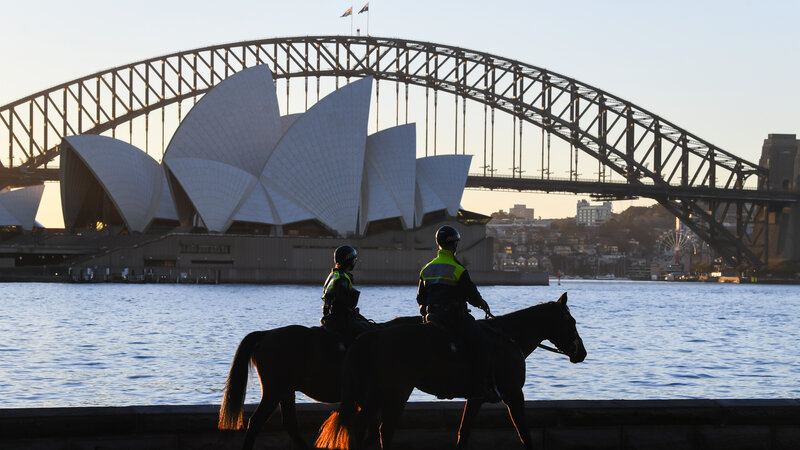 SYDNEY, AUSTRALIA - JULY 30: Two mounted police officers patrol around the edge of the harbour next to Mrs Macquarie's Chair on July 30, 2021 in Sydney, Australia. Covid-19 lockdown restrictions in hot spot local government areas have increased with masks required outdoors at all times and residents limited to movement within a 5 kilometre radius of their homes. Police have been given more authority to enforce public health orders with the help of the Australian Defence Force as Greater Sydney enters an extended lockdown through to August 28th in order to contain the highly contagious Covid-19 delta variant. (Photo by James D. Morgan/Getty Images)