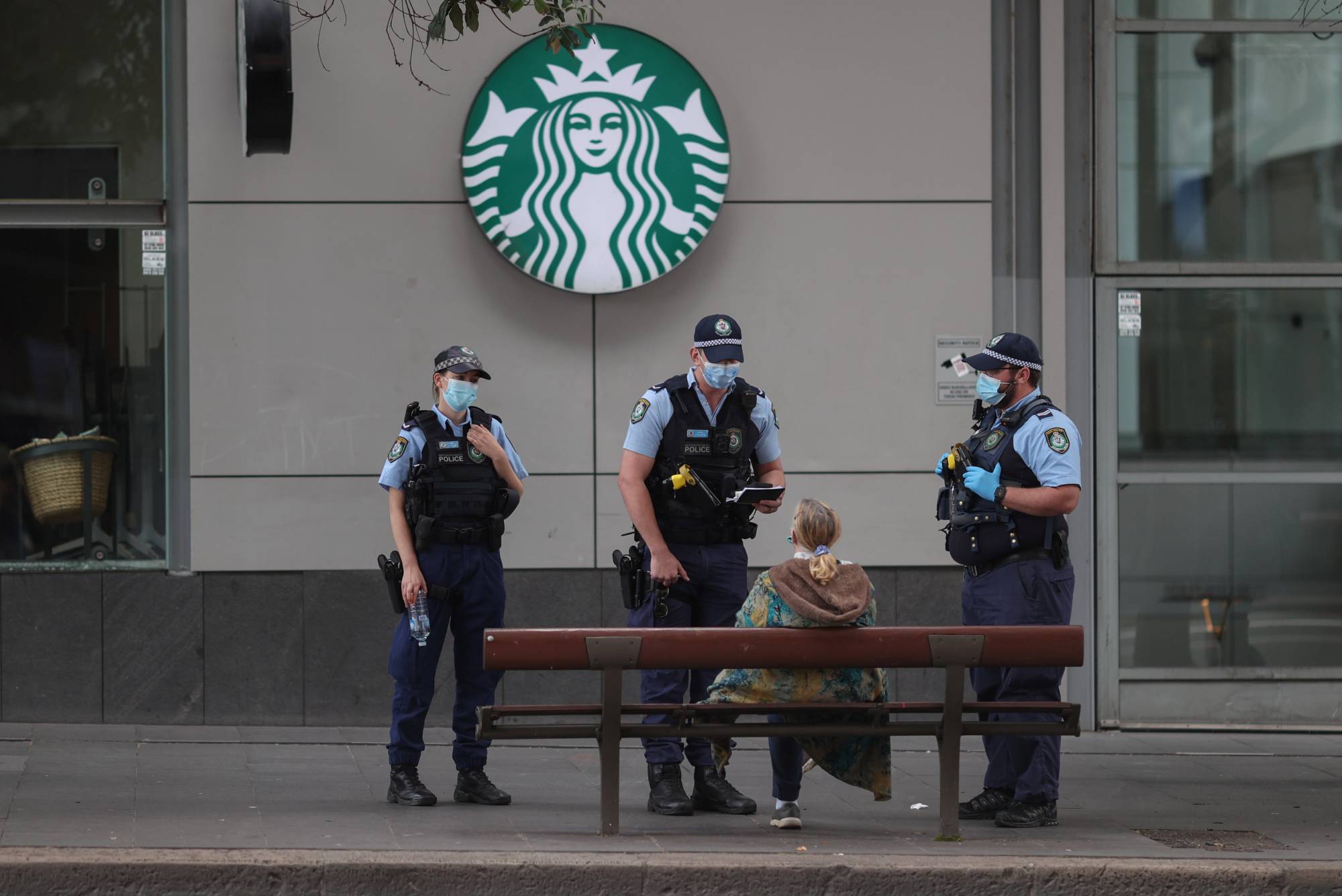 Police officers speak with a member of the public during a law enforcement operation to prevent anti-lockdown protesters from gathering during a lockdown to curb the spread of an outbreak of the coronavirus disease (COVID-19) in Sydney, Australia, July 31, 2021.  REUTERS/Loren Elliott