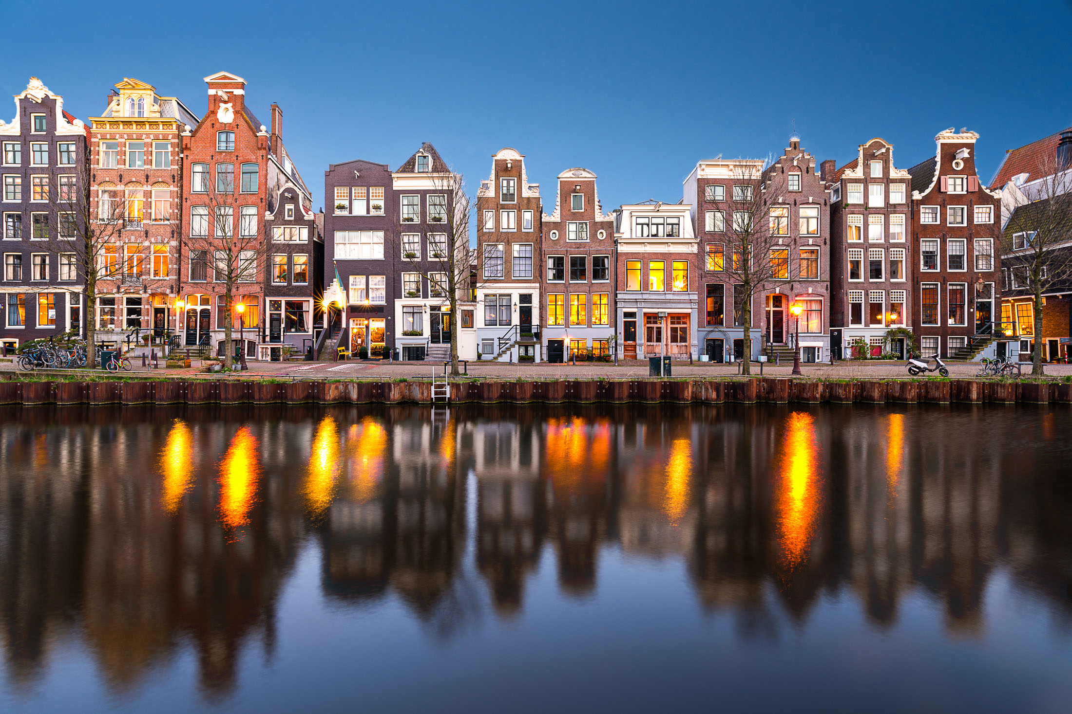This is a beautiful photo of the canal houses on the Herengracht canal in the center of Amsterdam. The unique architecture of the houses dates all the way back to the 16th century and now the whole city center is a UNESCO world heritage sites.