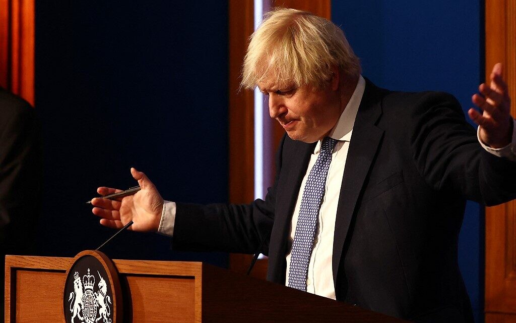 Britain's Prime Minister Boris Johnson gestures during a press conference for the latest Covid-19 update in the Downing Street briefing room in central London on December 8, 2021. - The UK government is reintroducing Covid-19 restrictions due to the Omicron variant. (Photo by Adrian DENNIS / POOL / AFP)