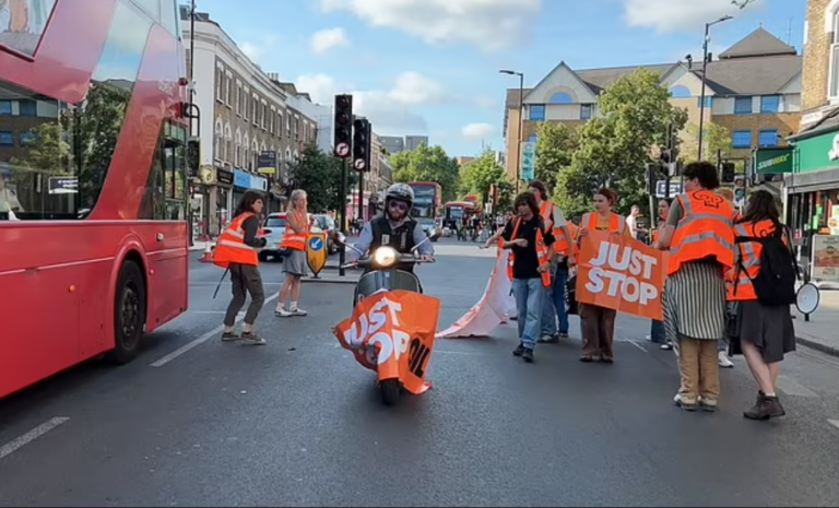 Moment Motorcyclist Ploughs Through Just Stop Oil Banner Before Tossing it on the Ground