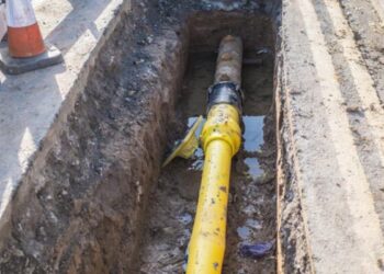Underground pipe being fixed in trench
